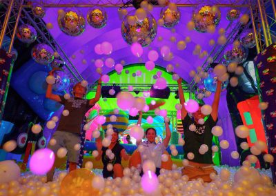 Friends throw balls in the air while in a ballpit
